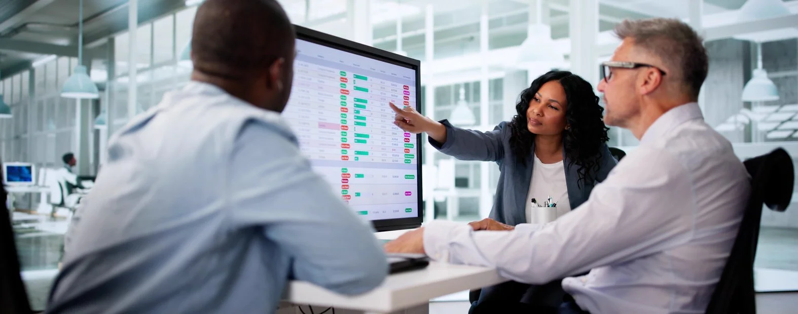 Three colleagues reviewing a risk dashboard together